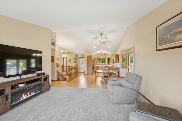24482 18th Ave, Saint Augusta, MN 56301 - living room with lofted ceiling, light colored carpet, a glass covered fireplace, light wood finished floors, and a ceiling fan