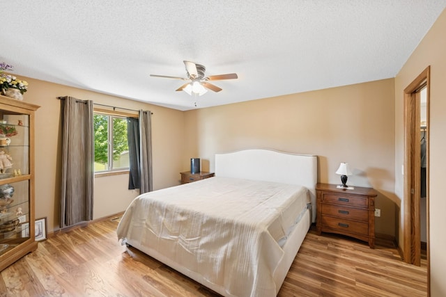 24482 18th Ave, Saint Augusta, MN 56301 - bedroom featuring wood finished floors, a textured ceiling, and a ceiling fan
