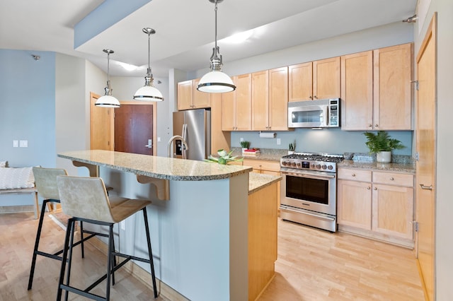 317 Groveland Ave Unit 106, Minneapolis, MN 55403 - kitchen with stainless steel appliances, light brown cabinets, light wood-type flooring, a breakfast bar area, and light stone countertops