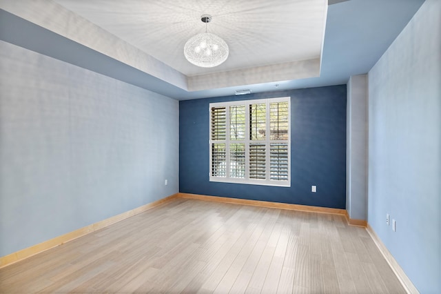 317 Groveland Ave Unit 106, Minneapolis, MN 55403 - spare room with a chandelier, wood finished floors, and a raised ceiling