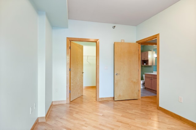 317 Groveland Ave Unit 106, Minneapolis, MN 55403 - unfurnished bedroom featuring light wood-style floors, a spacious closet, and a closet