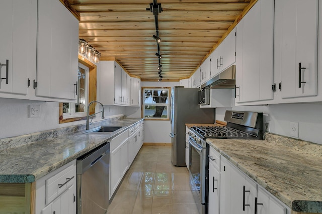 33027 County Road 50, Avon Twp, MN 56310 - kitchen with appliances with stainless steel finishes, under cabinet range hood, rail lighting, light tile patterned floors, and white cabinetry