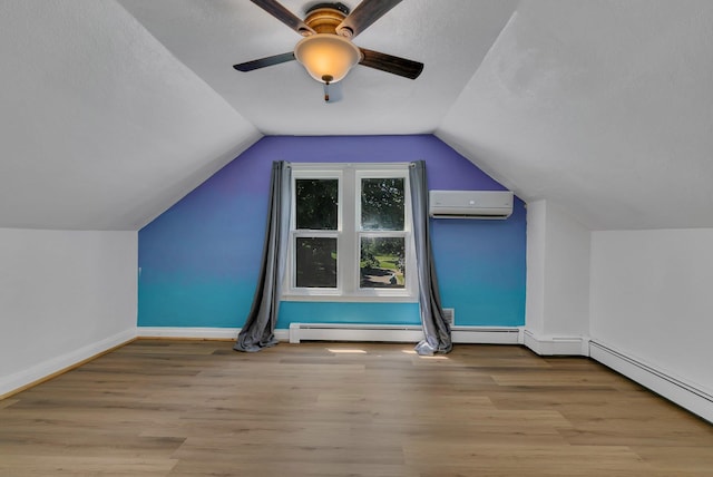 33027 County Road 50, Avon Twp, MN 56310 - additional living space featuring a wall mounted air conditioner, wood finished floors, a ceiling fan, vaulted ceiling, and a baseboard radiator