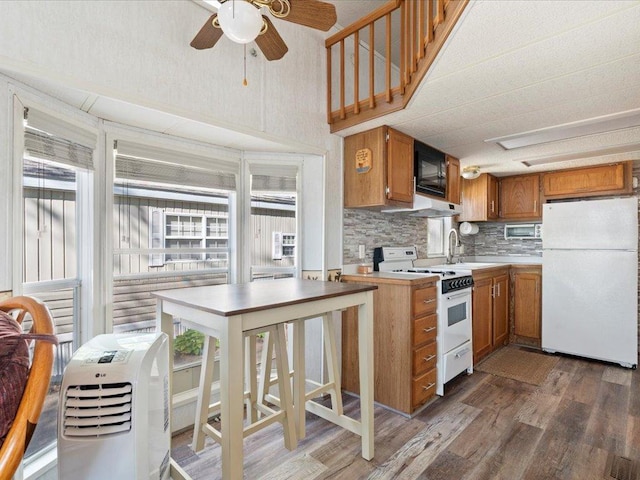 15827 Wilderness Trl Unit 30, Crosslake, MN 56442 - kitchen with white appliances, dark wood-type flooring, ceiling fan, tasteful backsplash, and brown cabinets