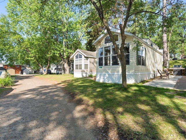 15827 Wilderness Trl Unit 30, Crosslake, MN 56442 - view of side of property with a lawn and a patio