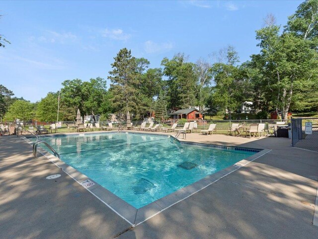 15827 Wilderness Trl Unit 112, Crosslake, MN 56442 - community pool featuring a patio and view of wooded area