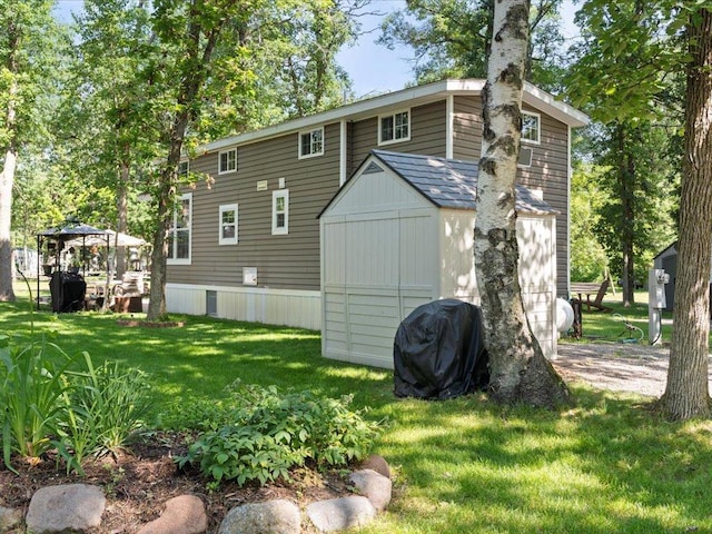 15827 Wilderness Trl Unit 112, Crosslake, MN 56442 - rear view of property featuring a gazebo, a storage unit, and a lawn