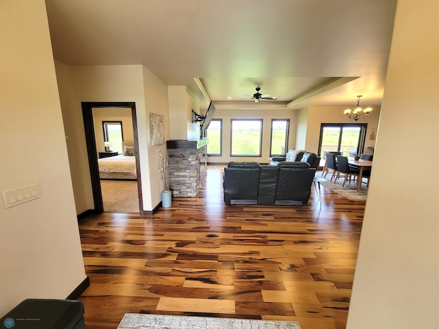 11003 Eagles Nest Ct, Audubon, MN 56511 - living room featuring hardwood / wood-style floors, a raised ceiling, a ceiling fan, and a chandelier
