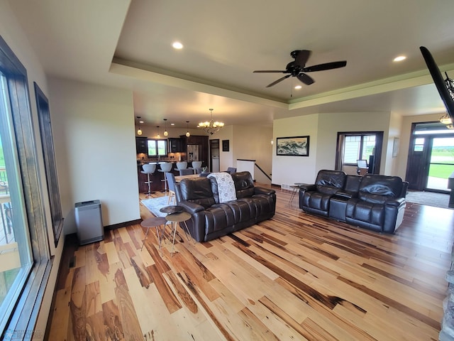 11003 Eagles Nest Ct, Audubon, MN 56511 - living area featuring a raised ceiling, a chandelier, light wood-style flooring, recessed lighting, and a ceiling fan