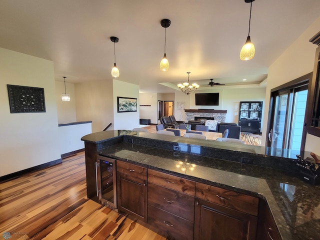 11003 Eagles Nest Ct, Audubon, MN 56511 - kitchen with beverage cooler, light wood-style floors, dark brown cabinets, and pendant lighting