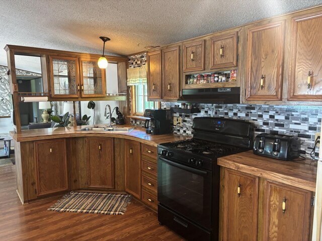 77165 Stepan Rd, Kettle River Twp, MN 55795 - kitchen with black gas range, under cabinet range hood, butcher block countertops, a textured ceiling, and tasteful backsplash