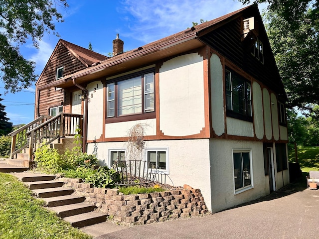 3821 Foss Rd, Saint Anthony, MN 55421 - view of home's exterior featuring stucco siding and a chimney