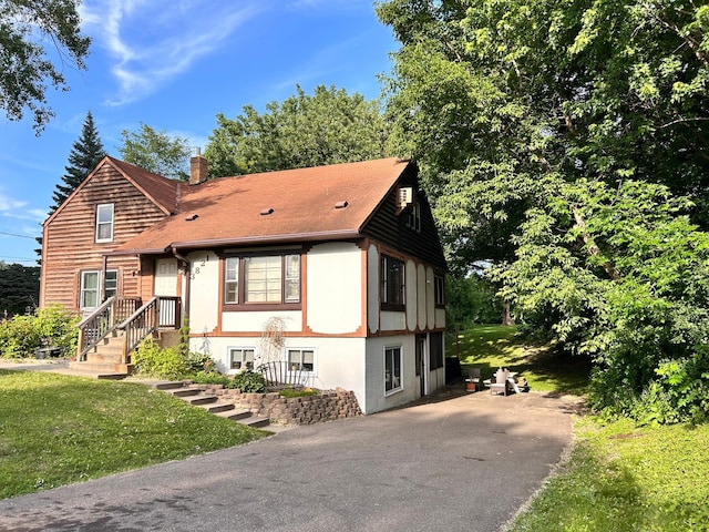 3821 Foss Rd, Saint Anthony, MN 55421 - view of front of home with a chimney, asphalt driveway, roof with shingles, and a front yard