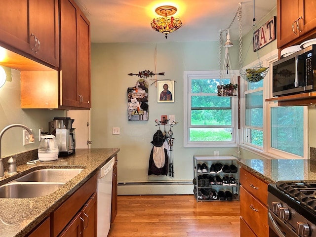 3821 Foss Rd, Saint Anthony, MN 55421 - kitchen featuring stainless steel appliances, light wood-type flooring, a baseboard heating unit, dark stone counters, and brown cabinets