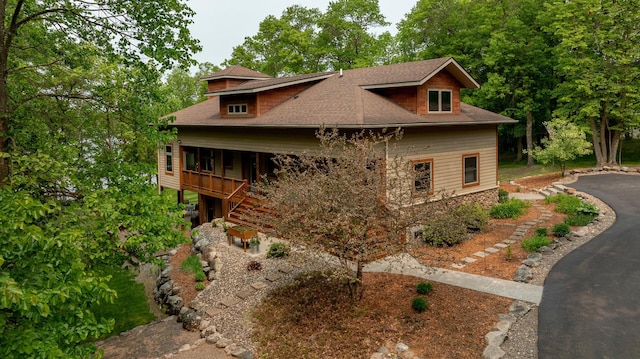 31767 Deacons Way, Pequot Lakes, MN 56472 - view of front of home featuring a shingled roof, stairway, stone siding, and asphalt driveway