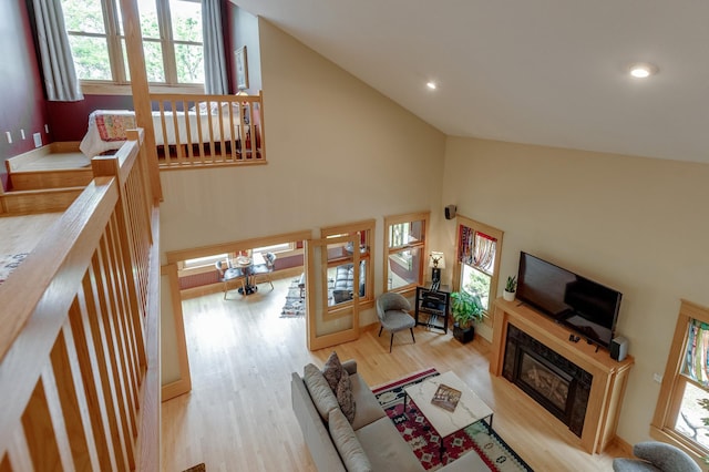 31767 Deacons Way, Pequot Lakes, MN 56472 - living area with a glass covered fireplace, wood finished floors, high vaulted ceiling, and recessed lighting