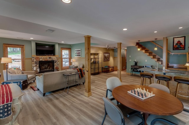 31767 Deacons Way, Pequot Lakes, MN 56472 - dining room with a stone fireplace, decorative columns, light wood finished floors, stairs, and recessed lighting