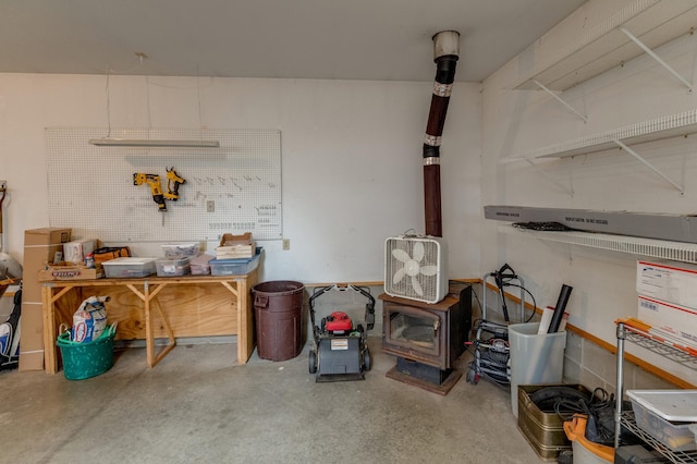 31767 Deacons Way, Pequot Lakes, MN 56472 - misc room featuring concrete flooring, a wood stove, and a workshop area