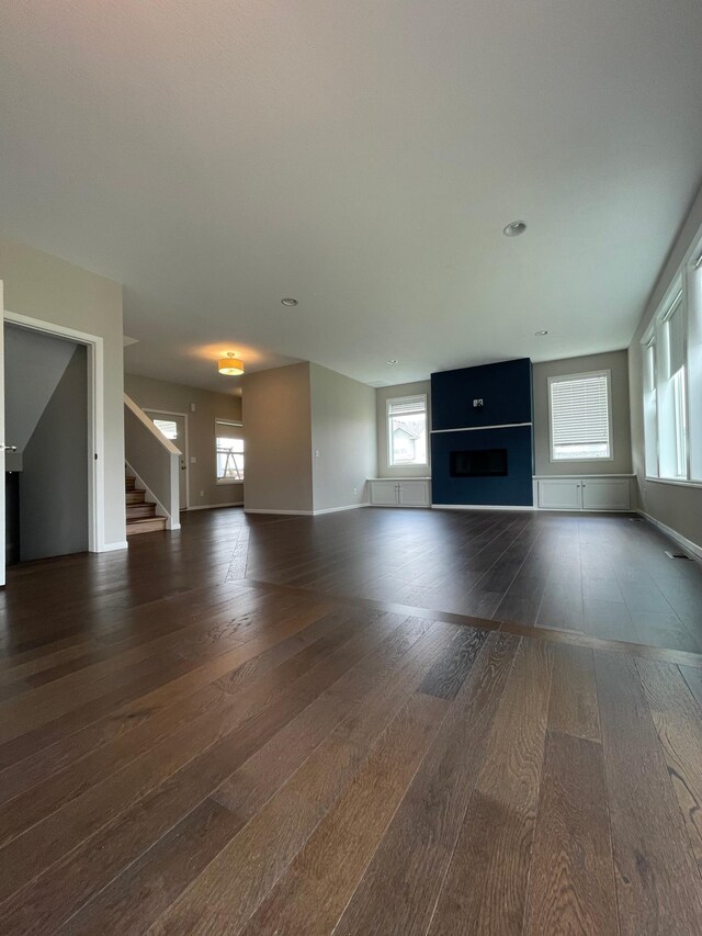 5437 154th St W, Apple Valley, MN 55124 - unfurnished living room featuring dark wood-style floors, a fireplace, and stairway