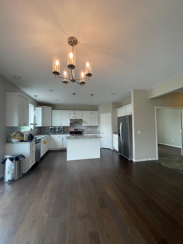 5437 154th St W, Apple Valley, MN 55124 - kitchen featuring stainless steel appliances, under cabinet range hood, backsplash, a chandelier, and dark wood-style floors