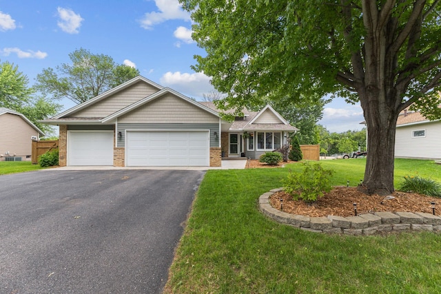 12816 95th Ave N, Maple Grove, MN 55369 - view of front of property featuring brick siding, asphalt driveway, a garage, and a front lawn
