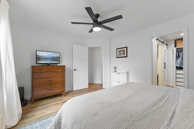 12816 95th Ave N, Maple Grove, MN 55369 - bedroom with wood finished floors, a barn door, and ceiling fan