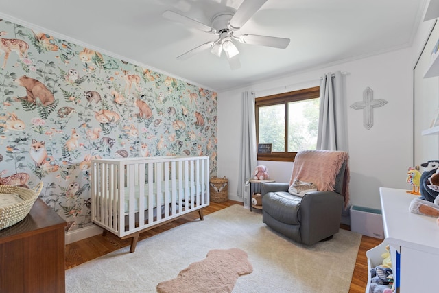 12816 95th Ave N, Maple Grove, MN 55369 - bedroom with wood finished floors, a crib, ornamental molding, and a ceiling fan