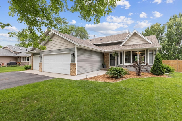 12816 95th Ave N, Maple Grove, MN 55369 - view of front facade with an attached garage, asphalt driveway, brick siding, a porch, and roof with shingles