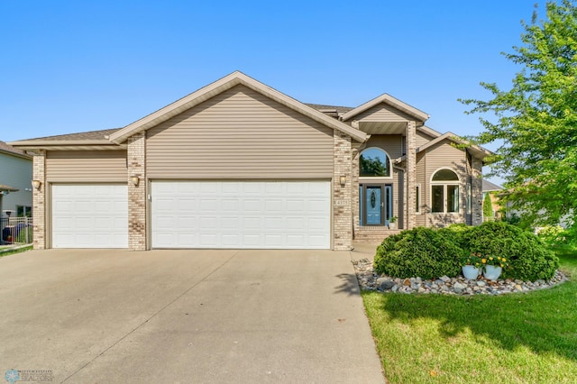 4375 58th St S, Fargo, ND 58104 - view of front of home with driveway, brick siding, a garage, and a front lawn