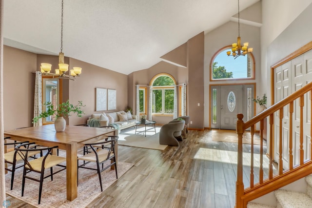 4375 58th St S, Fargo, ND 58104 - dining space with a chandelier, high vaulted ceiling, stairway, and hardwood / wood-style flooring