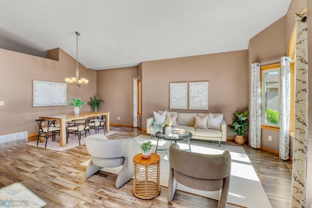 4375 58th St S, Fargo, ND 58104 - living area featuring a chandelier, vaulted ceiling, and hardwood / wood-style flooring