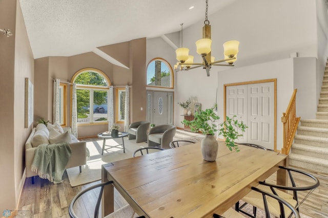 4375 58th St S, Fargo, ND 58104 - dining area featuring high vaulted ceiling, a chandelier, stairs, and wood finished floors