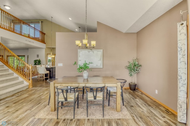 4375 58th St S, Fargo, ND 58104 - dining room with a chandelier, stairs, vaulted ceiling, and wood finished floors