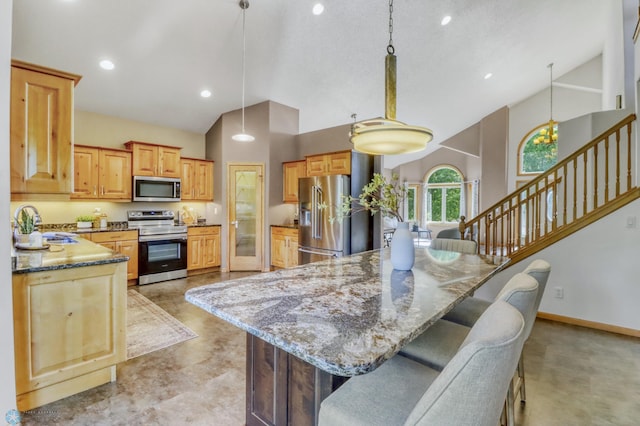 4375 58th St S, Fargo, ND 58104 - kitchen featuring appliances with stainless steel finishes, stone counters, a breakfast bar, high vaulted ceiling, and pendant lighting