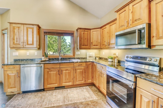 4375 58th St S, Fargo, ND 58104 - kitchen with appliances with stainless steel finishes, dark stone countertops, and high vaulted ceiling
