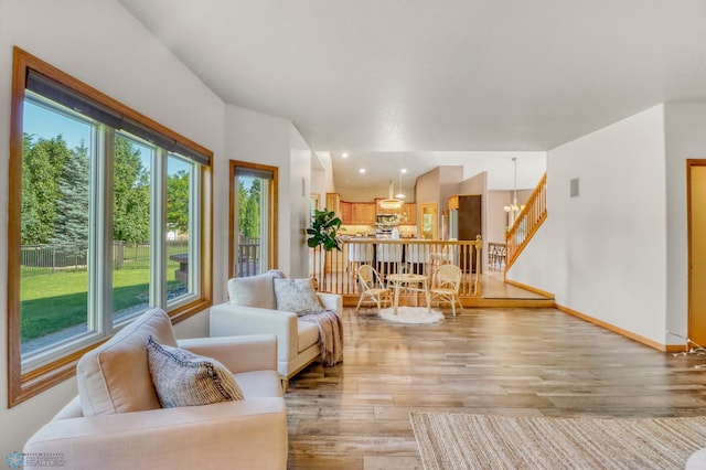 4375 58th St S, Fargo, ND 58104 - living room with light wood-style flooring, a chandelier, and stairway