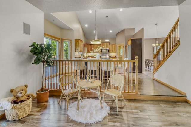 4375 58th St S, Fargo, ND 58104 - dining room featuring light wood-style floors, lofted ceiling, stairs, and recessed lighting