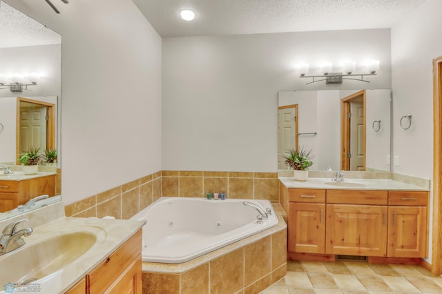 4375 58th St S, Fargo, ND 58104 - bathroom featuring two vanities, a tub with jets, tile patterned flooring, and a textured ceiling