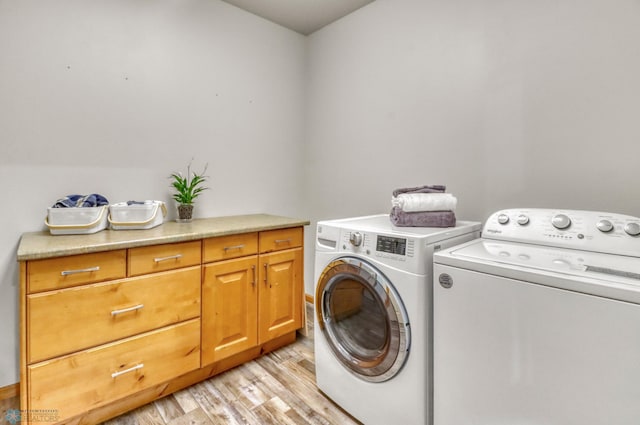 4375 58th St S, Fargo, ND 58104 - laundry area featuring washing machine and dryer, light wood-style flooring, and cabinet space