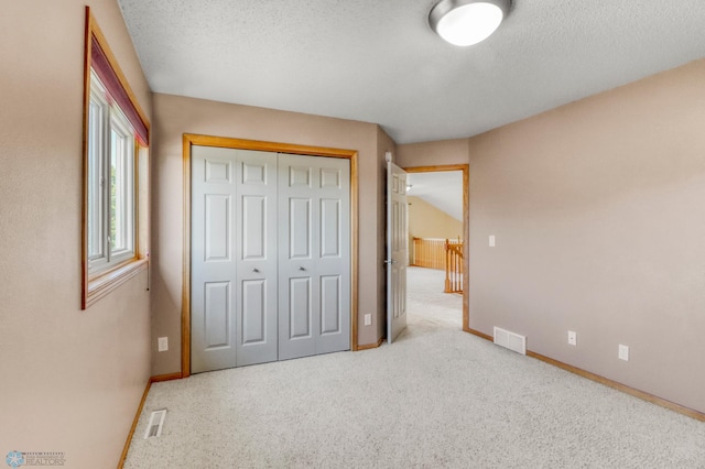 4375 58th St S, Fargo, ND 58104 - unfurnished bedroom with a textured ceiling, a closet, and carpet flooring