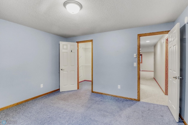 4375 58th St S, Fargo, ND 58104 - unfurnished bedroom featuring carpet floors, a textured ceiling, a spacious closet, and a closet