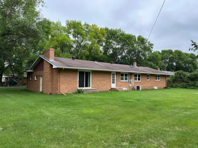 402 6th St NE, Barnesville, MN 56514 - rear view of property featuring a chimney, brick siding, entry steps, and a lawn