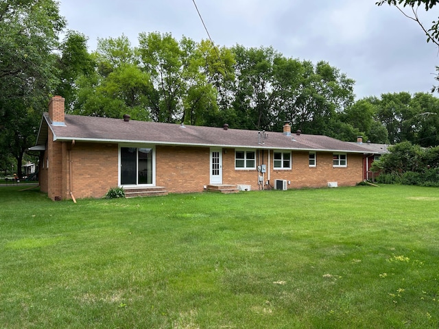 402 6th St NE, Barnesville, MN 56514 - rear view of house featuring a chimney, brick siding, entry steps, and a lawn