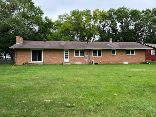 402 6th St NE, Barnesville, MN 56514 - back of house with entry steps, a chimney, brick siding, a lawn, and a shingled roof