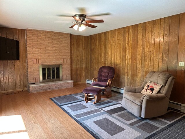 402 6th St NE, Barnesville, MN 56514 - living room with a ceiling fan, wood finished floors, a baseboard heating unit, and wood walls