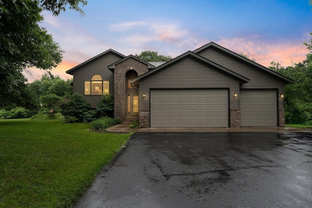 26943 140th St NW, Zimmerman, MN 55398 - view of front of property with brick siding, driveway, an attached garage, and a front yard