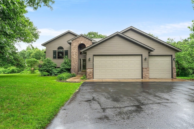 26943 140th St NW, Zimmerman, MN 55398 - view of front of house featuring brick siding, asphalt driveway, an attached garage, and a front lawn