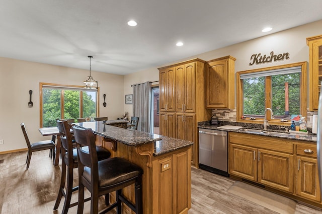 26943 140th St NW, Zimmerman, MN 55398 - kitchen with dishwasher, a kitchen island, brown cabinetry, a breakfast bar, and recessed lighting