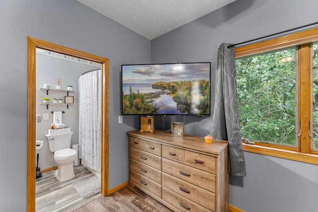 26943 140th St NW, Zimmerman, MN 55398 - bedroom with wood finished floors, a textured ceiling, and ensuite bath