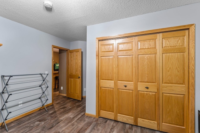 26943 140th St NW, Zimmerman, MN 55398 - unfurnished bedroom featuring dark wood-type flooring, a textured ceiling, and a closet